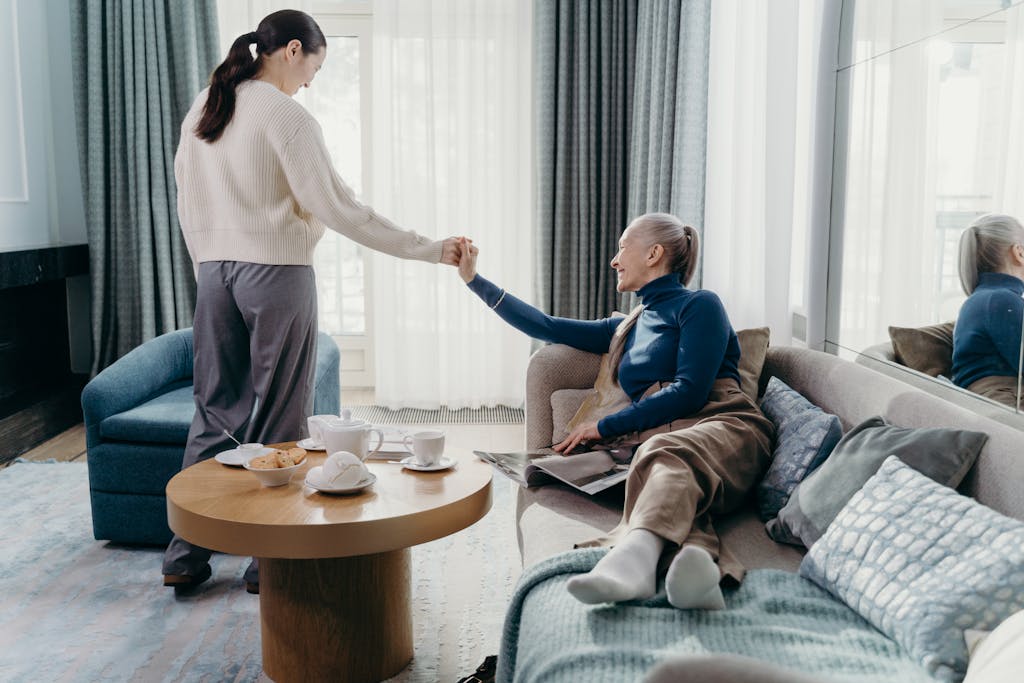A senior woman and her adult daughter enjoy quality time relaxing at home.